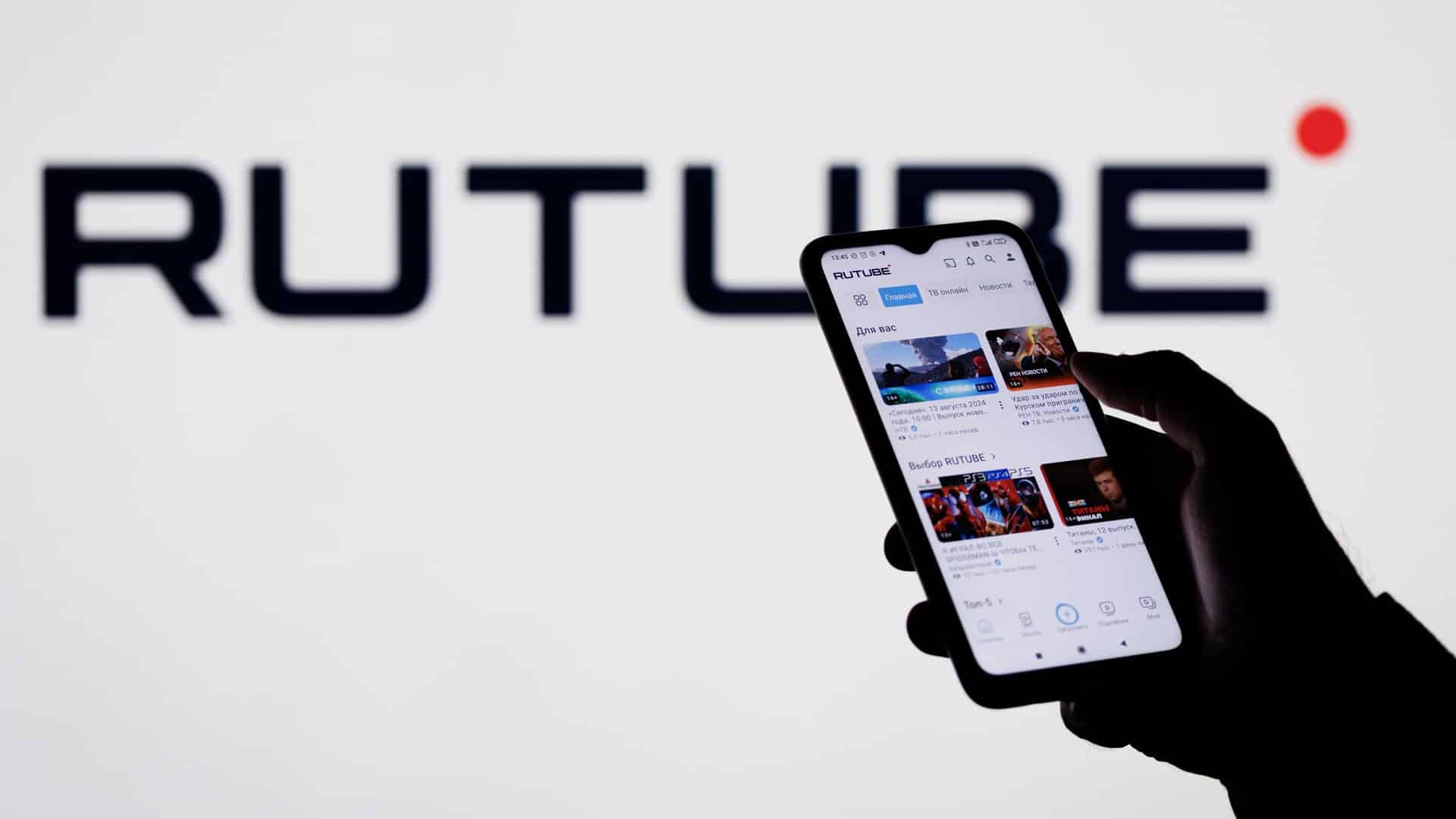 человек смотрит Rutube на телефоне