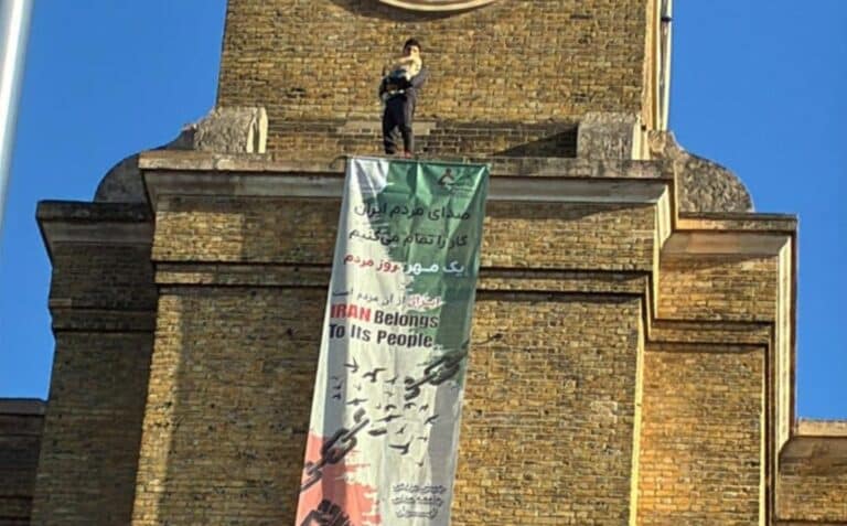 Protester Scales King’s Cross Clock Tower With Dog, Unfurls Anti-Iranian Regime Flag