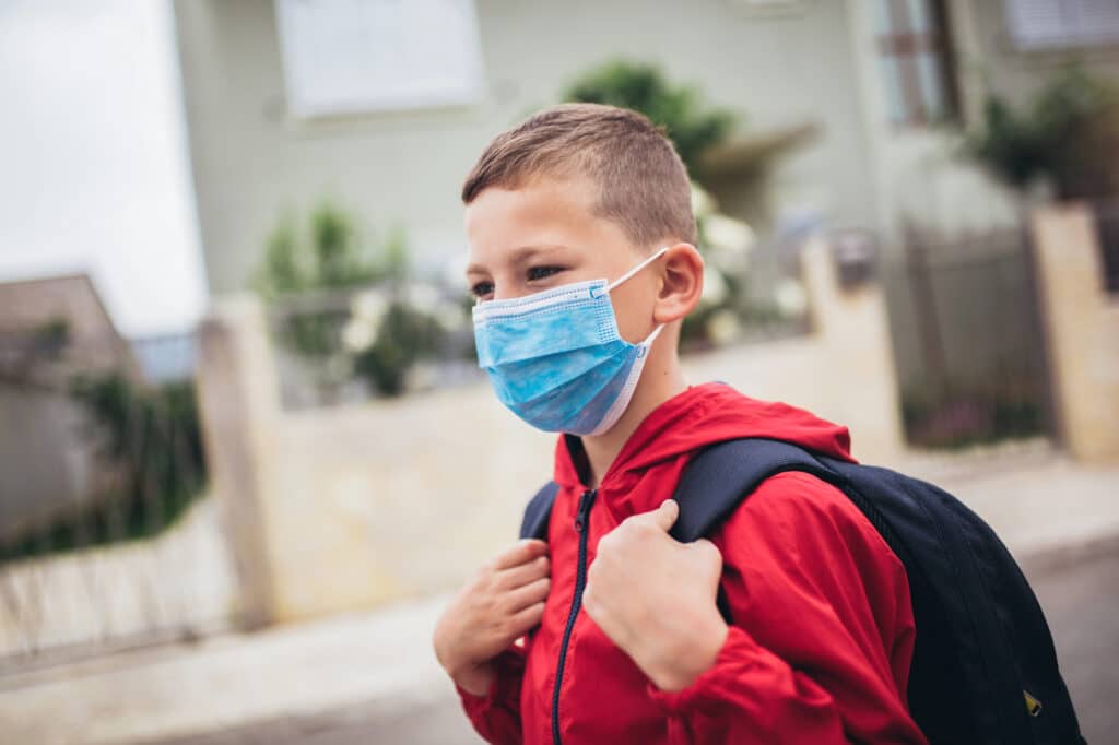 Ребёнок выходит на улицу в защитной маске во время смога